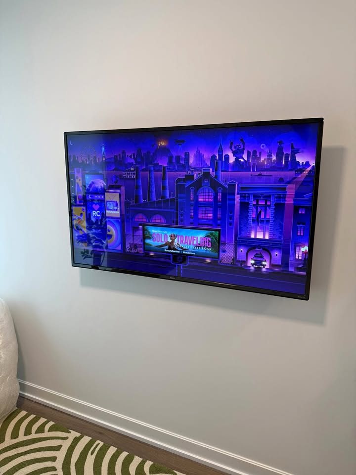 TV mounted on a light gray bedroom wall