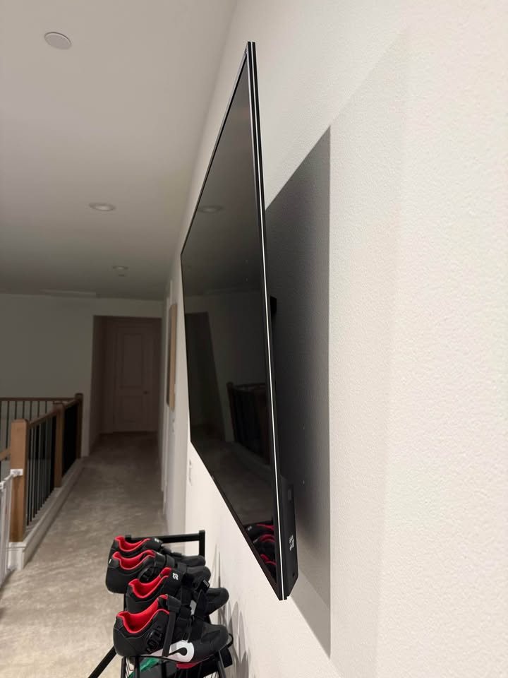 Side view of a TV mounted close to the wall in an upstairs hallway